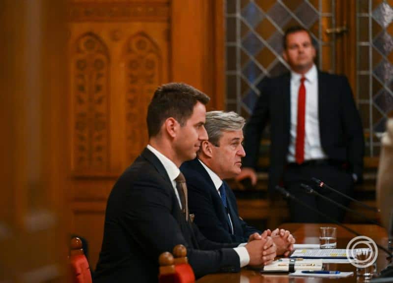 Magyar politikusok egy tárgyalóteremben, komoly beszélgetés közben.